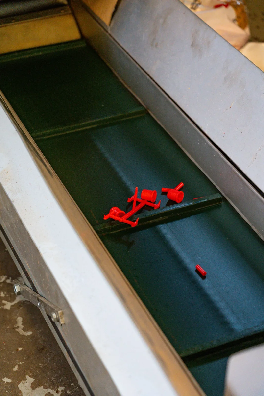 Moulded plastic parts on a production conveyor at Malvern Plastics
